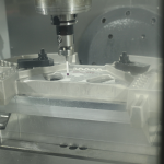 Customer image from Conturo Prototyping showing their use of Fusion 360 and the Fusion 360 Machining Extension. Image shows the inside of a CNC machine as it uses a spindle-mounted probe to take measurements on a component.